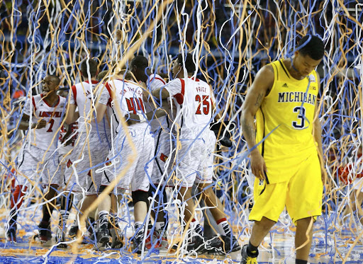 Michigan Wolverines guard Trey Burke (3) walks off the court as the Louisville Cardinals celebrate defeating Michigan to win the NCAA mens Final Four championship basketball game in Atlanta, Georgia April 8, 2013.   REUTERS/Jeff Haynes (UNITED STATES  - Tags: SPORT BASKETBALL TPX IMAGES OF THE DAY)   ORG XMIT: ATL159