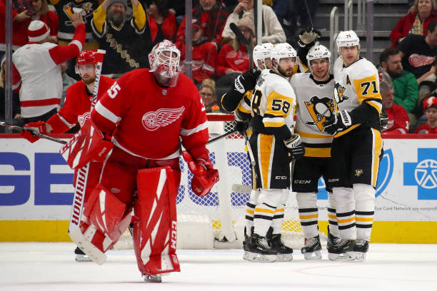 DETROIT, MICHIGAN - JANUARY 17: Sidney Crosby #87 of the Pittsburgh Penguins celebrates his game winning overtime goal with Evgeni Malkin #71 and Kris Letang #58 behind Jimmy Howard #35 of the Detroit Red Wings at Little Caesars Arena on January 17, 2020 in Detroit, Michigan. Pittsburgh won the game 2-1 in overtime. (Photo by Gregory Shamus/Getty Images)