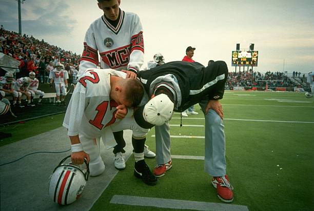 High School Football: McKinley High QB Josh McDaniels (12) with coach, his father Thom McDaniels on sidelines after losing game with overtime point after tochdown by Massillon HS at Paul Brown Tiger Stadium. 100th annual game of rivalry. Masillion, OH 11/5/1994 CREDIT: Lynn Johnson (Photo by Lynn Johnson /Sports Illustrated via Getty Images) (Set Number: X47246 TK2 )