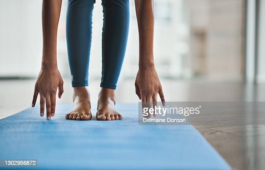 Shot of an unrecognisable woman practicing a yoga routine at home